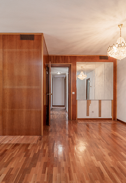 empty-room-with-varnished-wood-mural-mirrors-crystal-chandelier-matching-parquet-floors