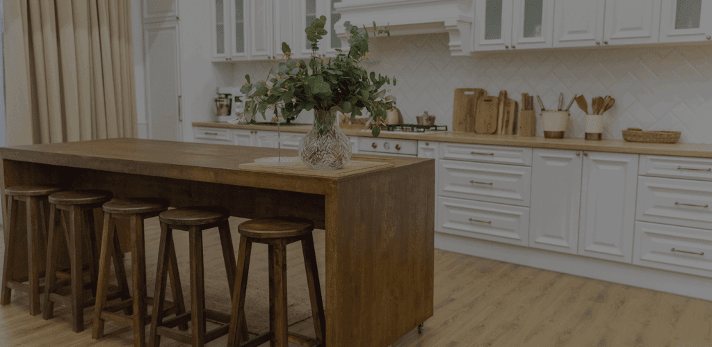 Shaker-Style Cabinets and a Large Wooden Kitchen Island with Matching Wooden Stools
